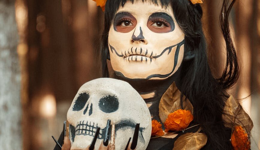 woman in halloween costume with skull in hands